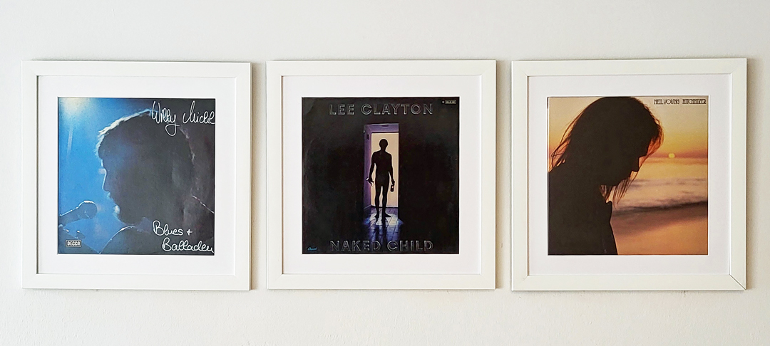 Drei gerahmte Schallplattencover mit Personen in Silhouette – darunter Neil Young.