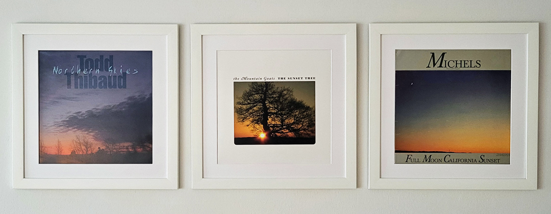 Drei Schallplattencover mit stimmungsvollen Sonnenuntergängen als Motiv, nebeneinander präsentiert.