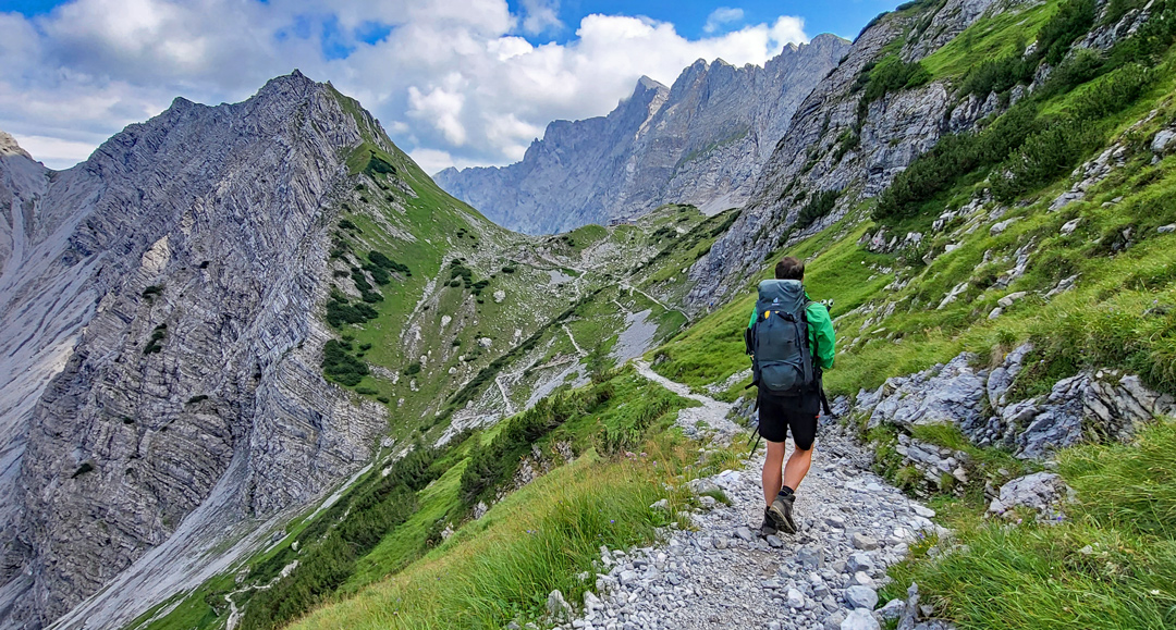 Fernwanderer mit Rucksack auf einem Steig im Karwendel.