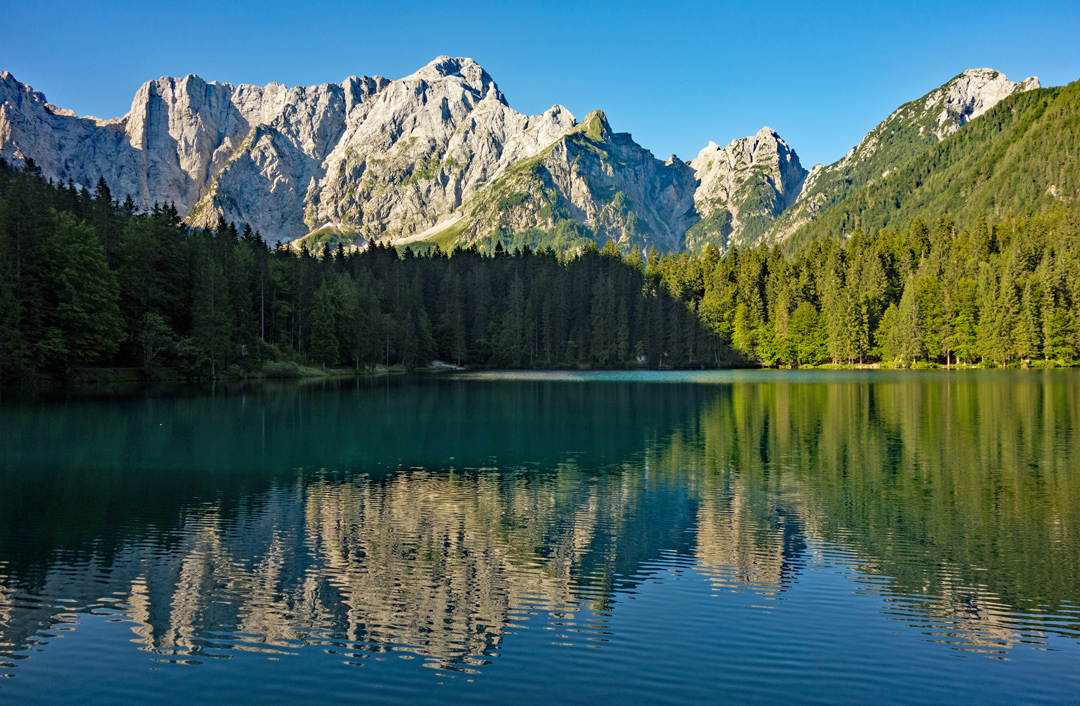 Die beeindruckenden Felswände der Julischen Alpen spiegeln sich im Unteren Weißenfelser See.